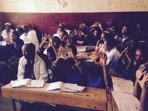 Students modeling the hand symbol representing the cognitive process of compare and contrast for a Double Bubble Map.